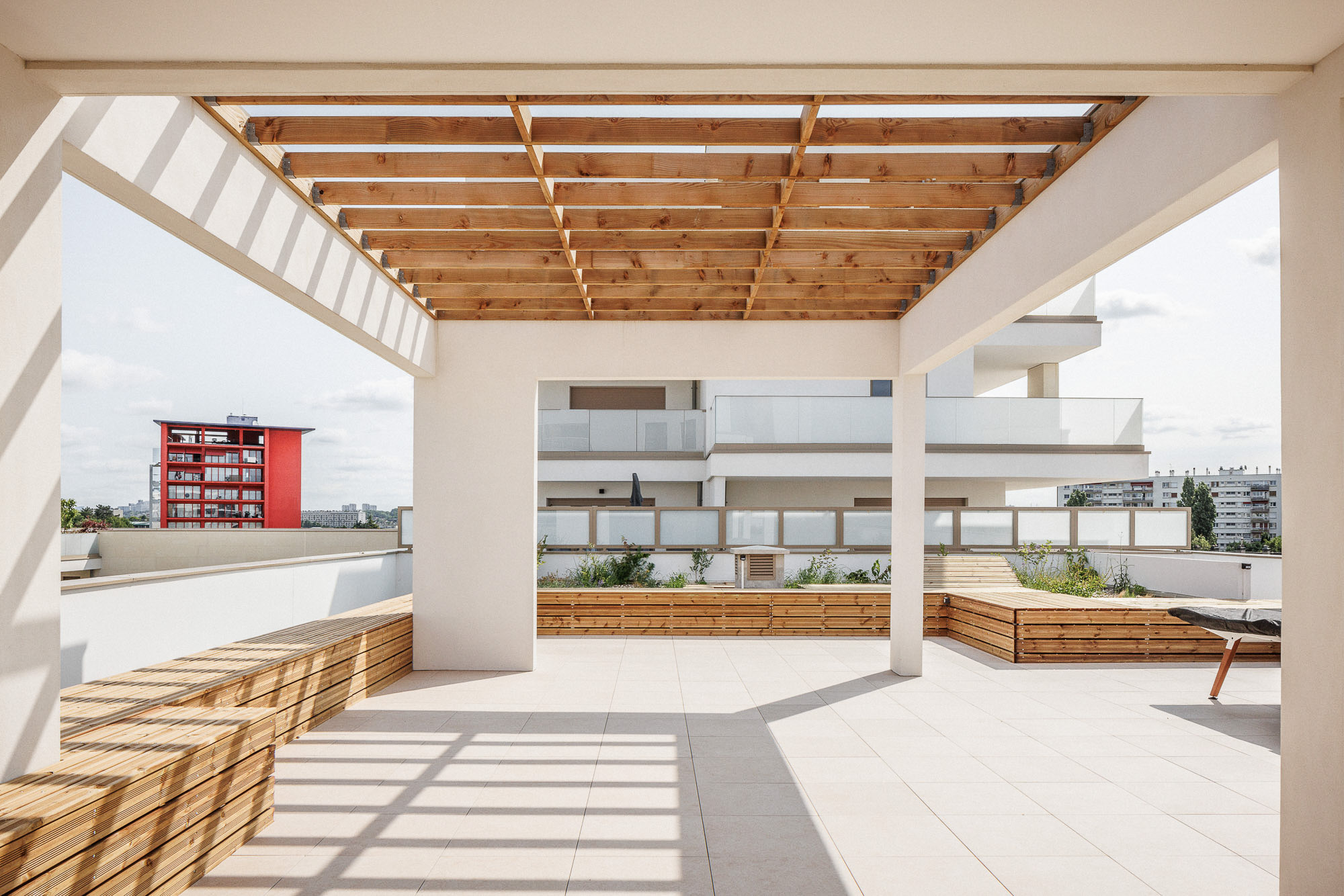 Toiture terrasse (rooftop) commun à l'ensemble des logements ZAC Jean Zay à Antony, avec banc et pergola en bois, par Cussac Architectes et Associés (ca+a)